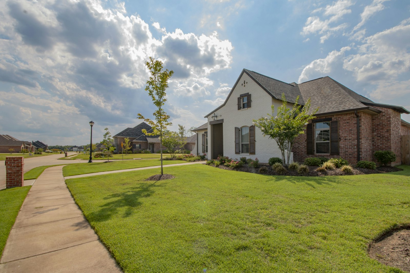 A freshly maintained lawn and landscaped front yard of a New England home